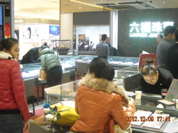 營業員細心陪伴一位女士挑選心儀的首飾